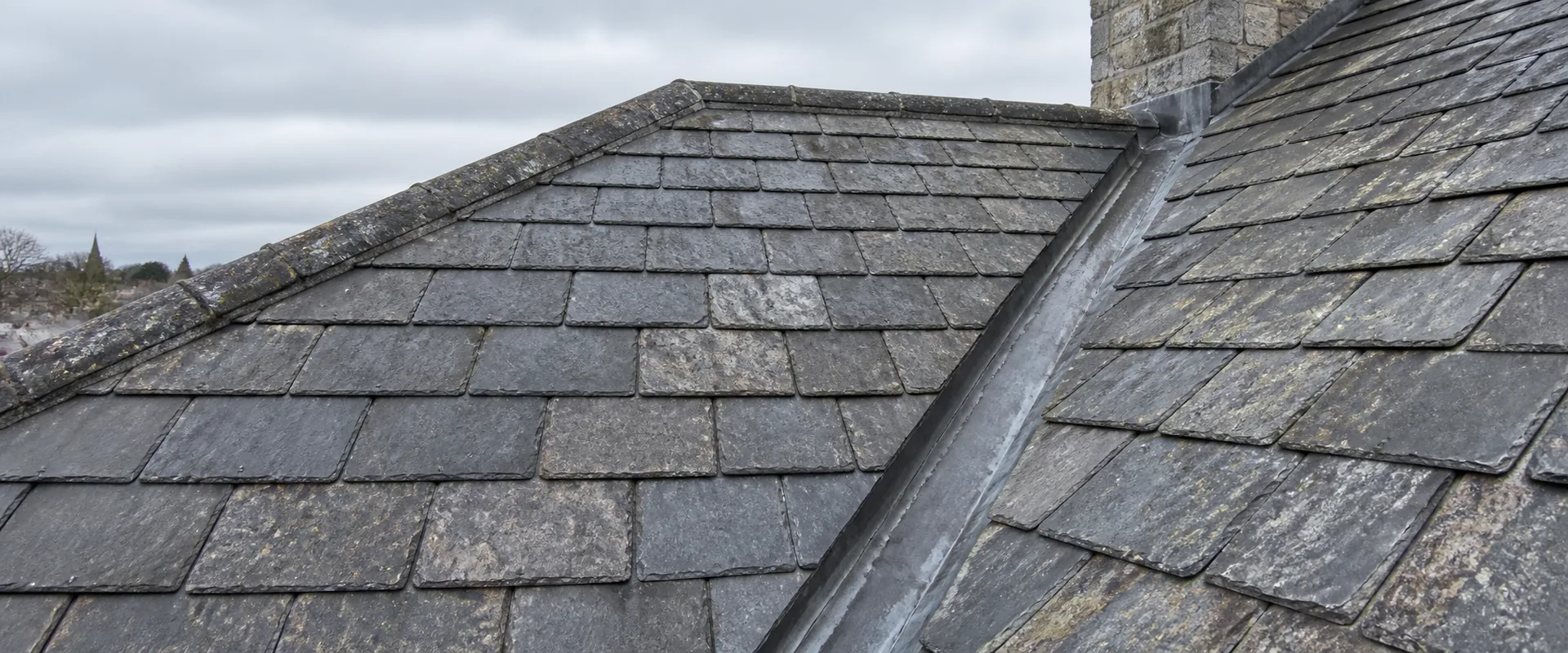Illustrative open lead-lined valley between two slate-roof slopes.